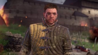 Henry standing in front of a burning village in Kingdom Come: Deliverance