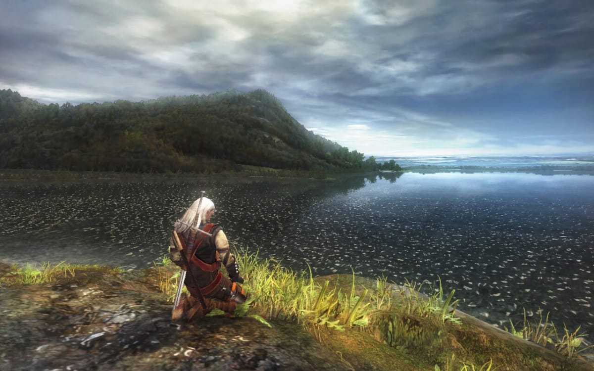 The Witcher Remake screenshot showing the main character on his knees looking out at a body of water.