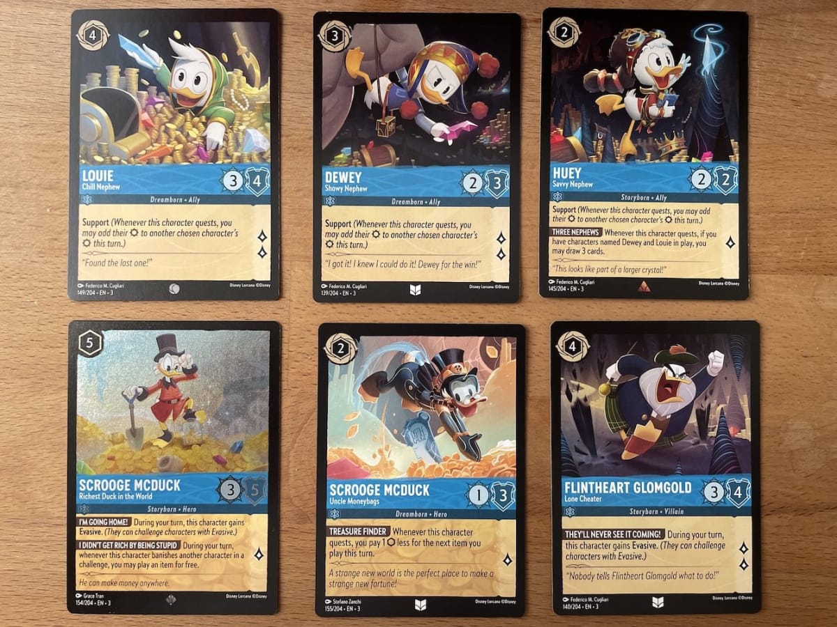 An image from our Disney Lorcana Into The Inklands Starter Deck Review featuring supportive Sapphire cards featuring characters from Ducktales