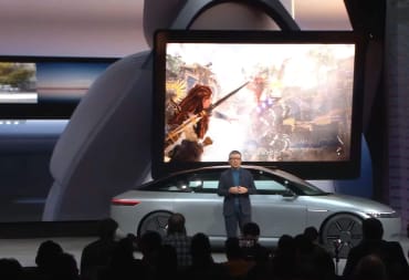 Sony Honda Mobility CEO Yasuhide Mizuno standing in front of a new Afeela car with a PS5 game running on it