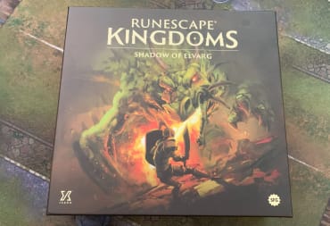 A screenshot of a box of Runescape Kingdoms Shadow of Elvarg on a gaming mat.