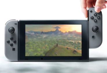 A Nintendo Switch console can be seen with one Joy Con being removed by a hand.