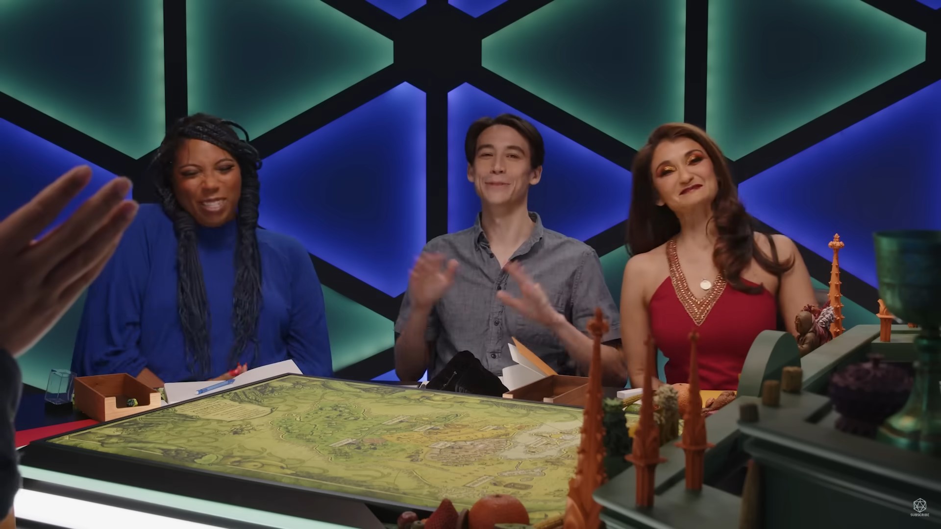 Anjali, Zac, and Aabria sitting on half of the table in The Ravening War