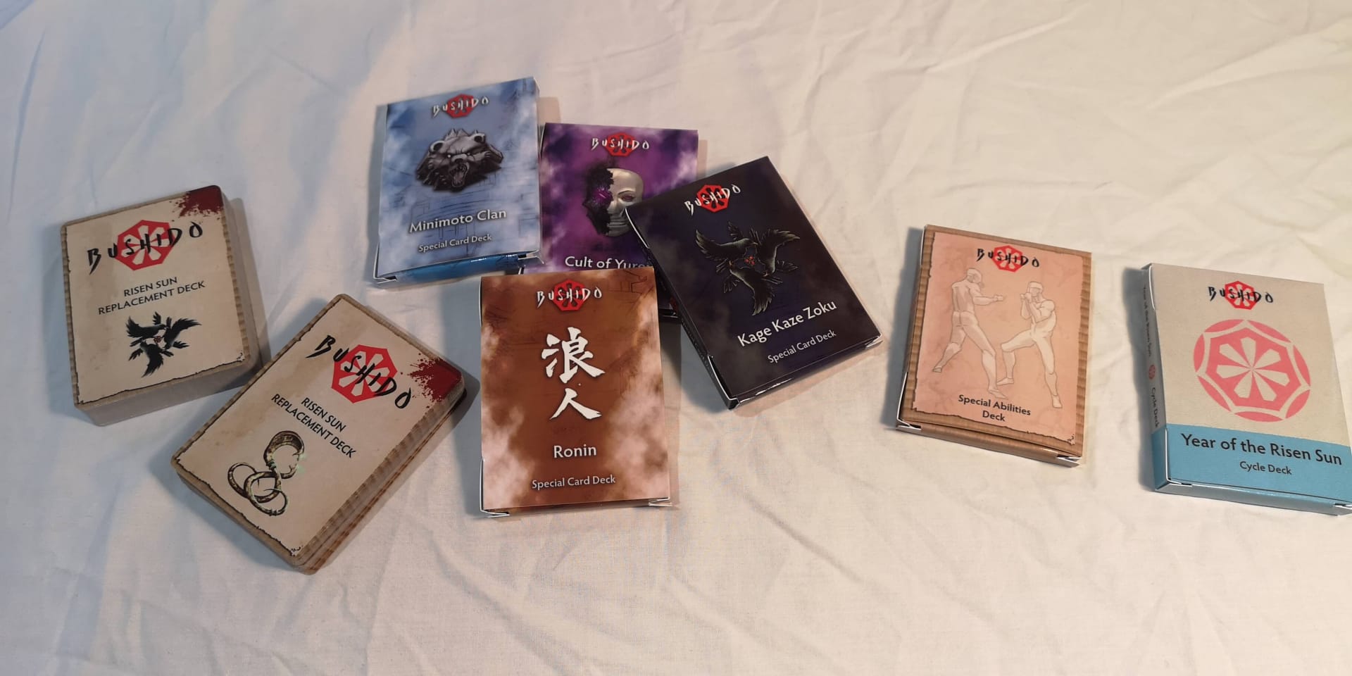 The various card packs for Bushido Risen Sun.