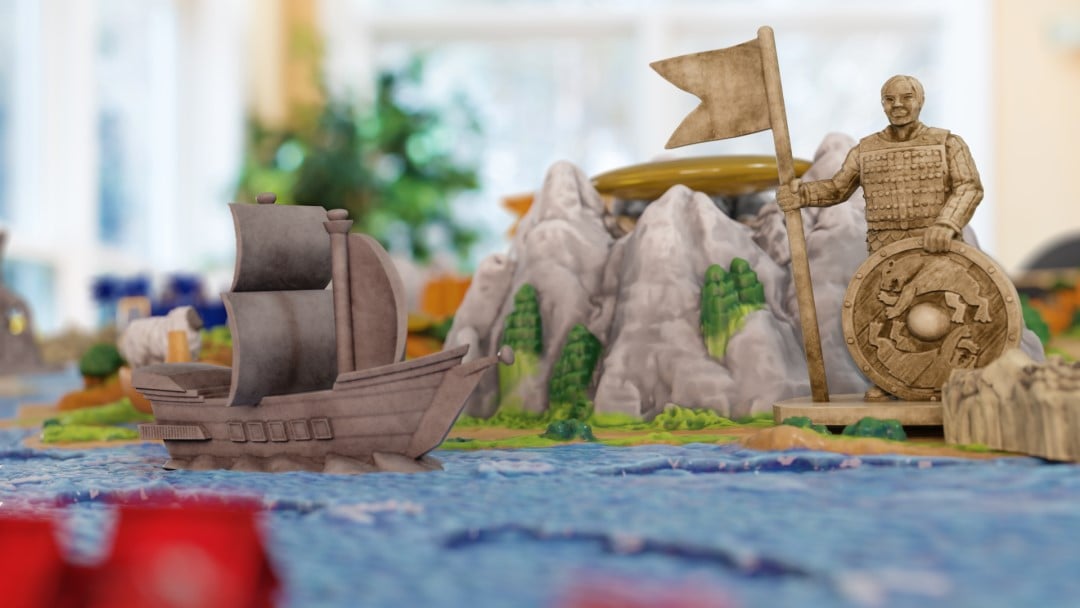 A close up of statues, water, and boat pieces from the Catan 3D Expansions