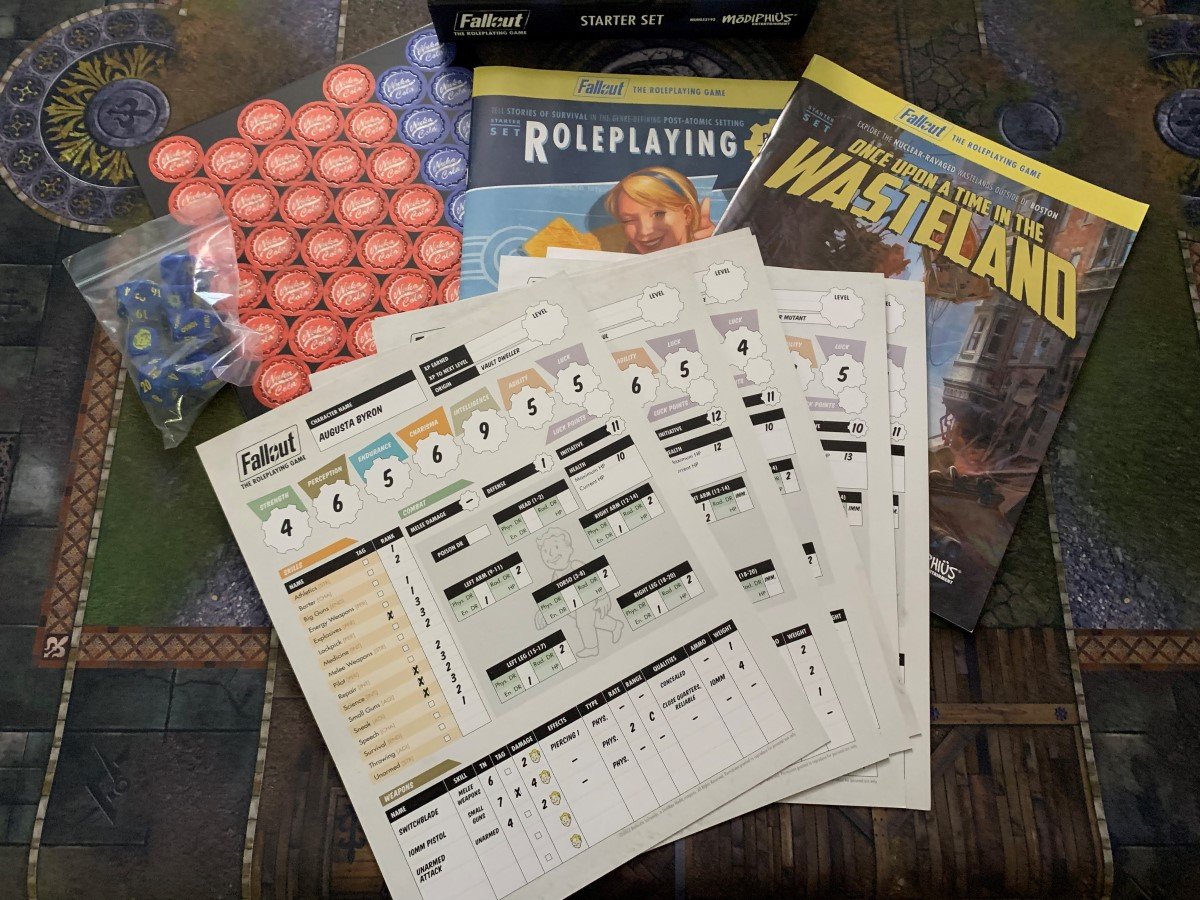 A spread of game pieces, sheets, and rulebooks from the Fallout RPG Starter Set