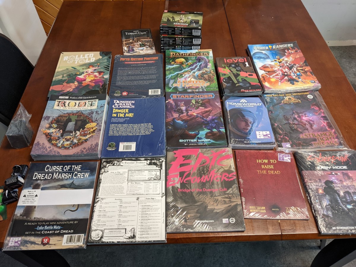 A table with various RPG books and accessories shown