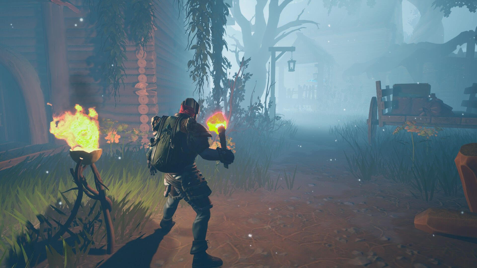 The player holding a torch in a misty village in Frozen Flame