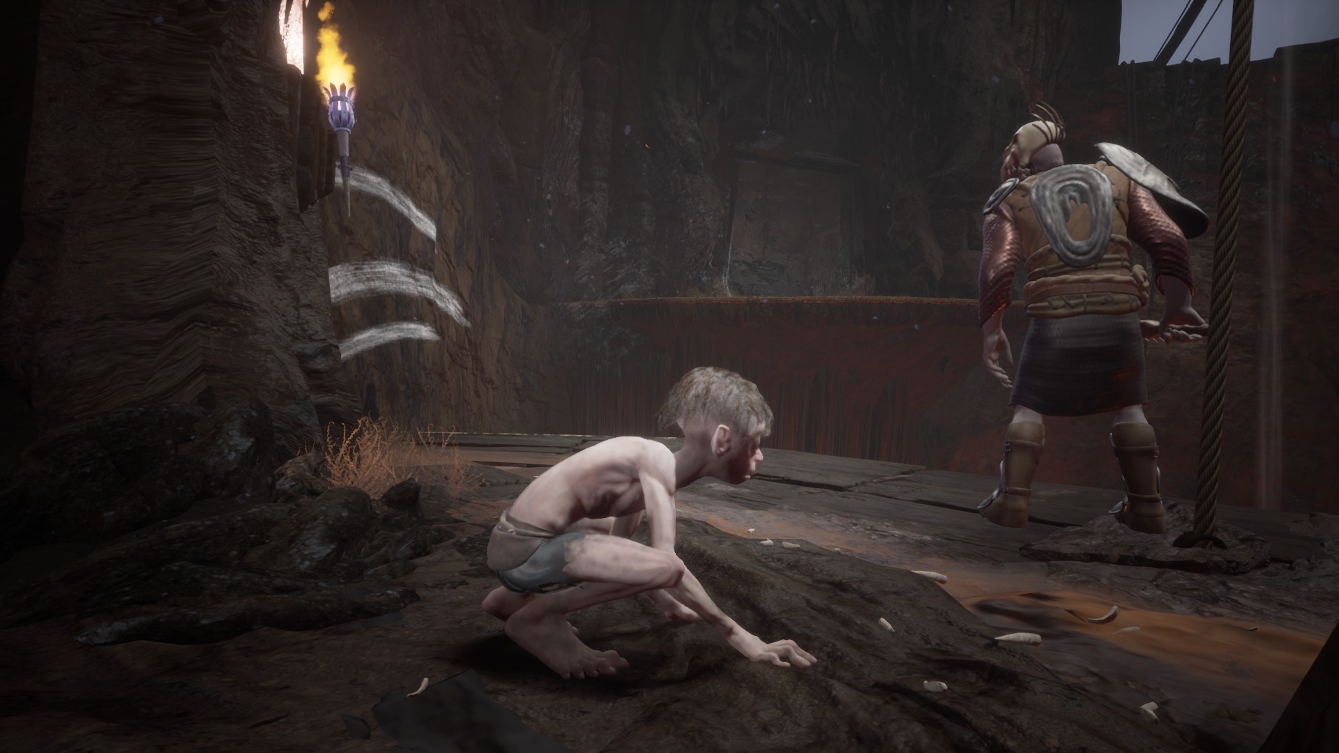 Gollum screenshot showing gollum looking at an orc who has his back turned next to a ledge and a wall with white marks across it. 