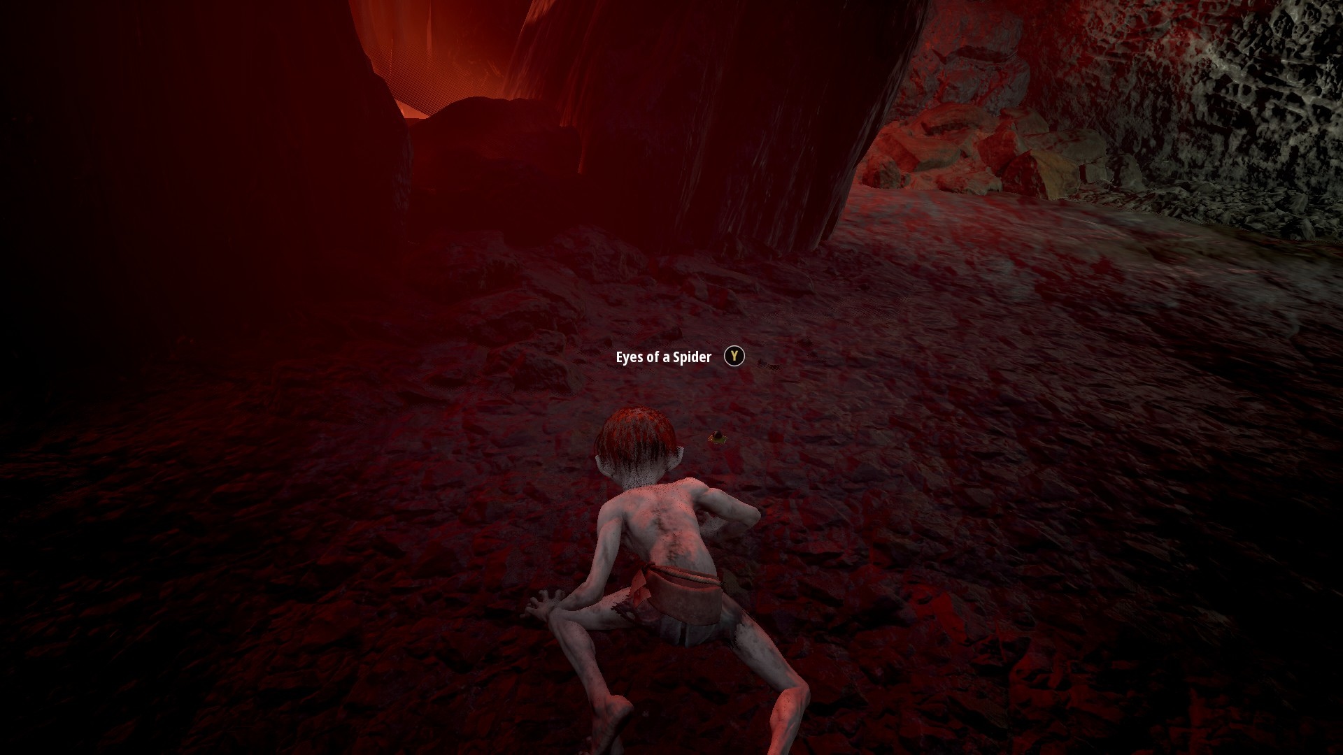 Gollum screenshot showing Gollum crawling low to the ground in a dark cave. 