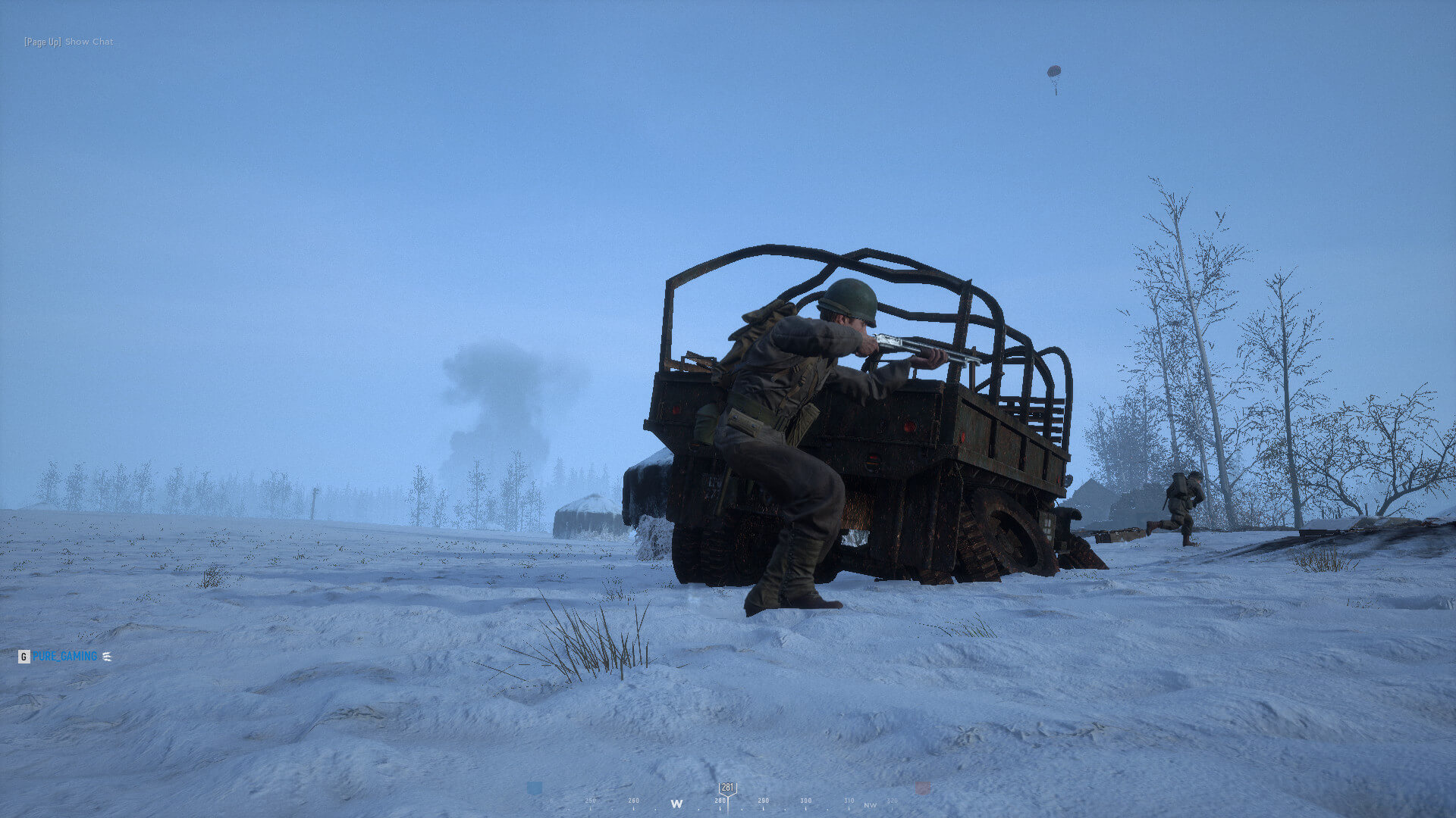 A player crouching behind a burnt-out vehicle in Hell Let Loose