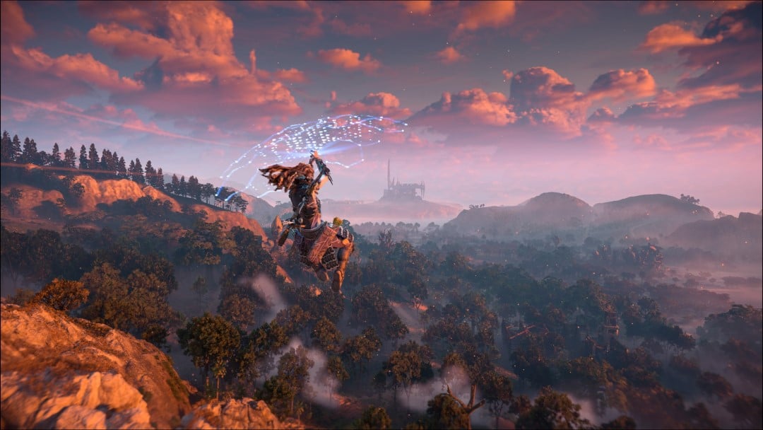 Aloy gliding through the air with a ruin in the distance