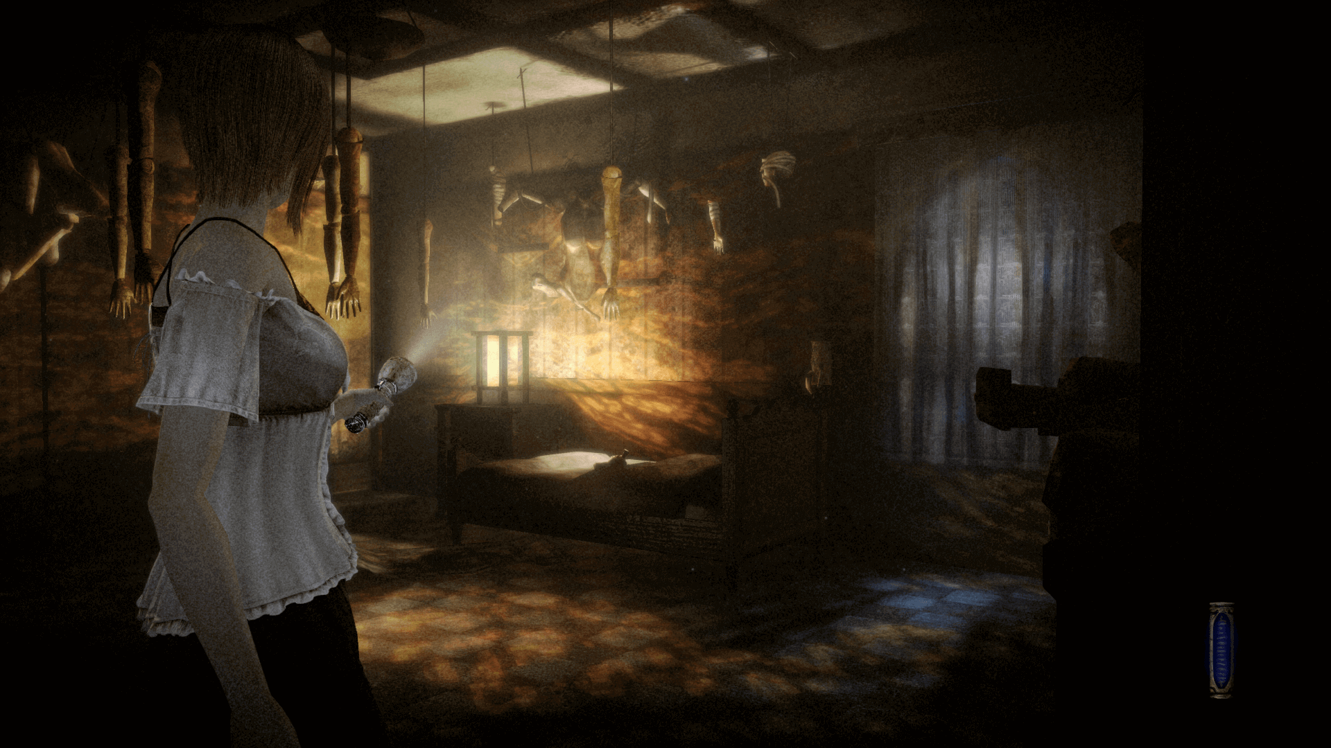 An in-game screenshot of Fatal Frame: Mask of The Lunar Eclipse, showcasing the character Misaki Asou standing inside a brightly-lit room, with mannequin hands dangling from string tied to the ceiling.