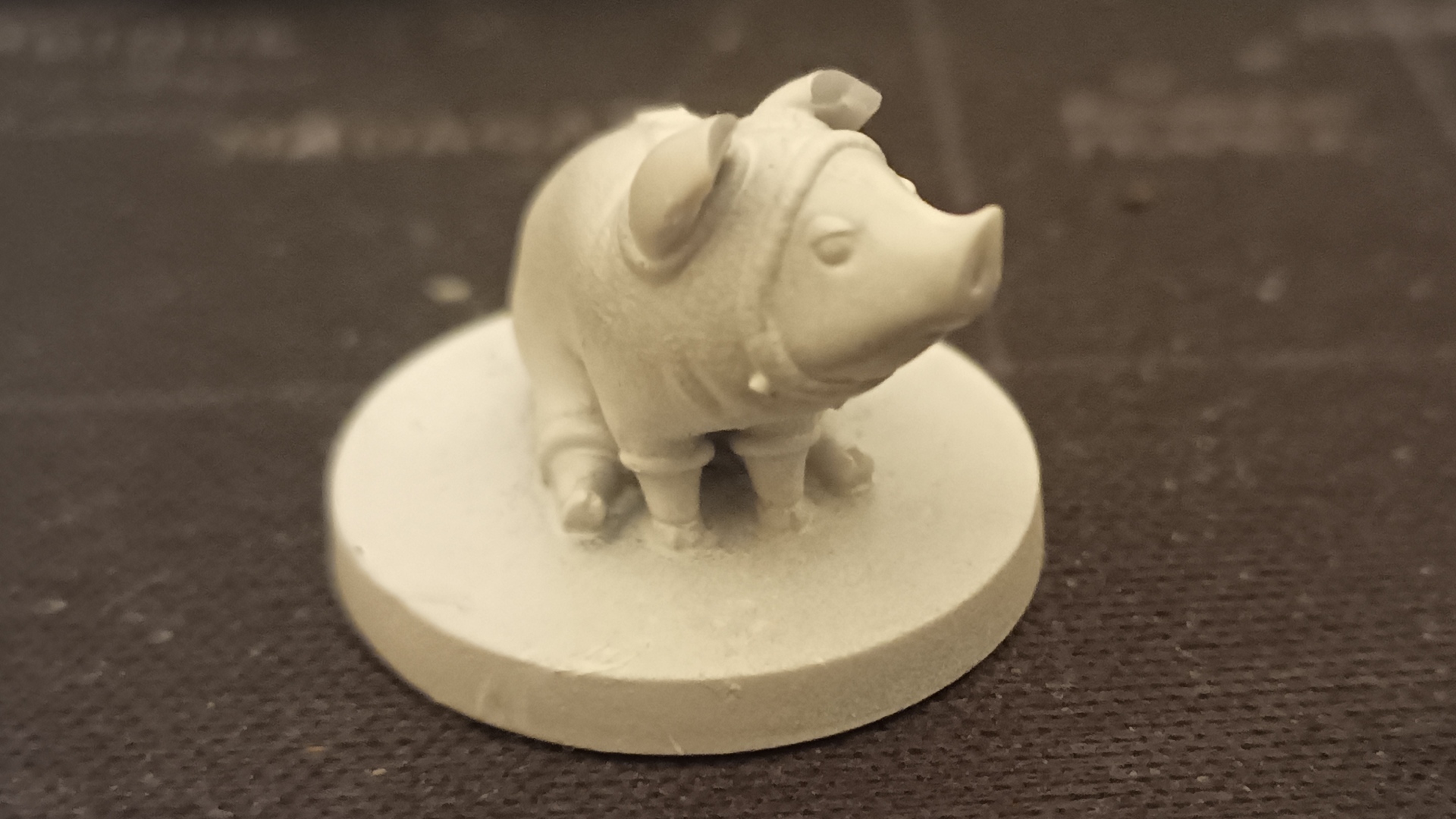 Extreme closeup of a miniature of a poogie, a pig-like creature that wears a onesie. 