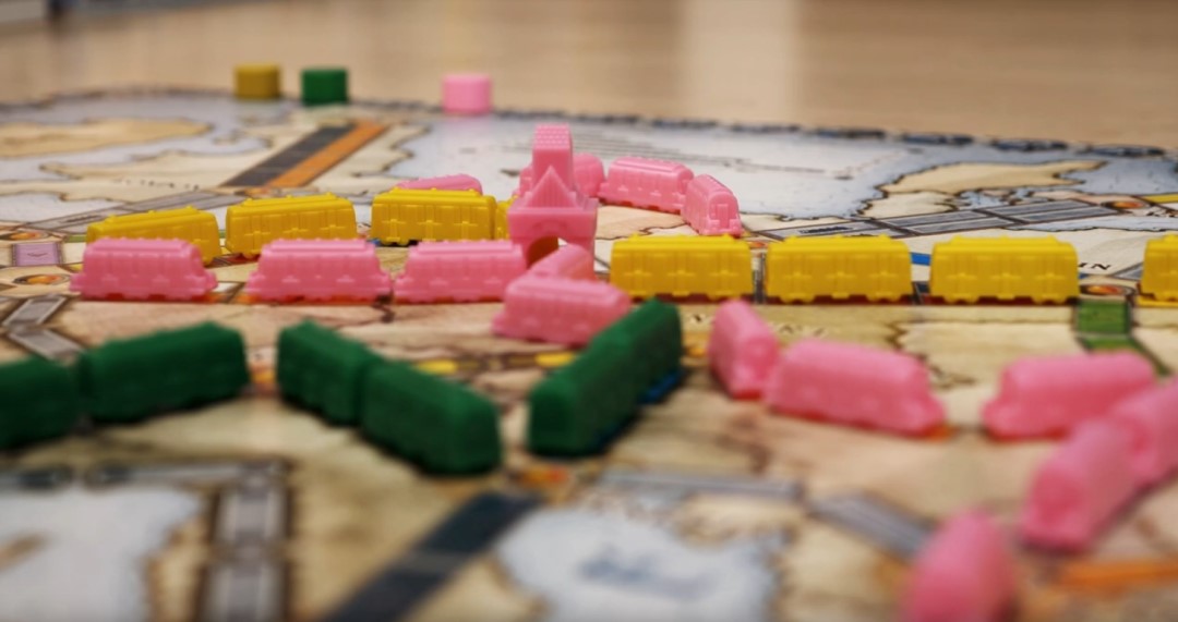 A board of Ticket To Ride with pink trains seen on the board