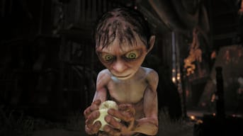 Gollum screenshot showing gollum looking curiously at a small bird he is holding in his hands. 