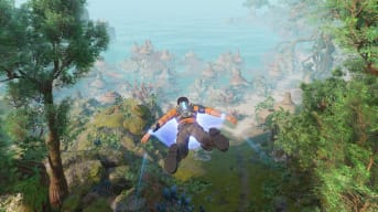 Outcast a New Beginning screenshot showing a man in an orange top gliding over a lush forest heading for a coastal fishing village