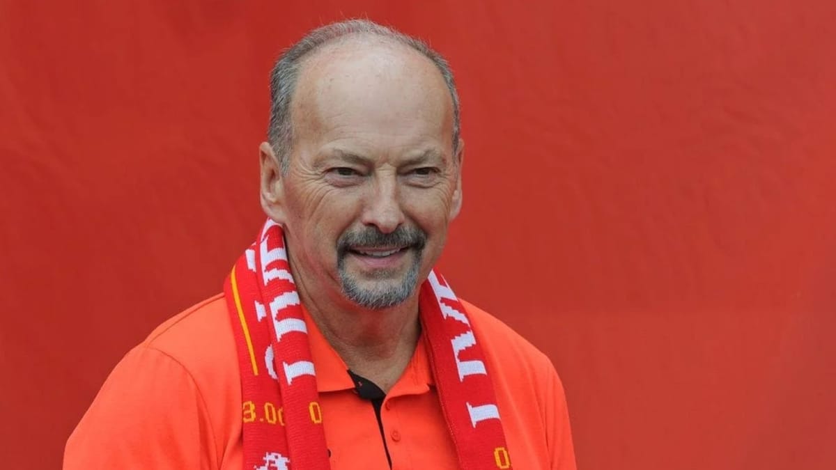 Peter Moore can be seen with a Liverpool FC scarf on