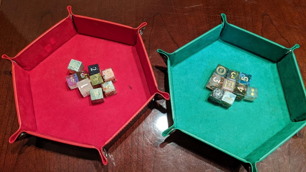 A picture of two rolling trays with 9 six-sided dice in each