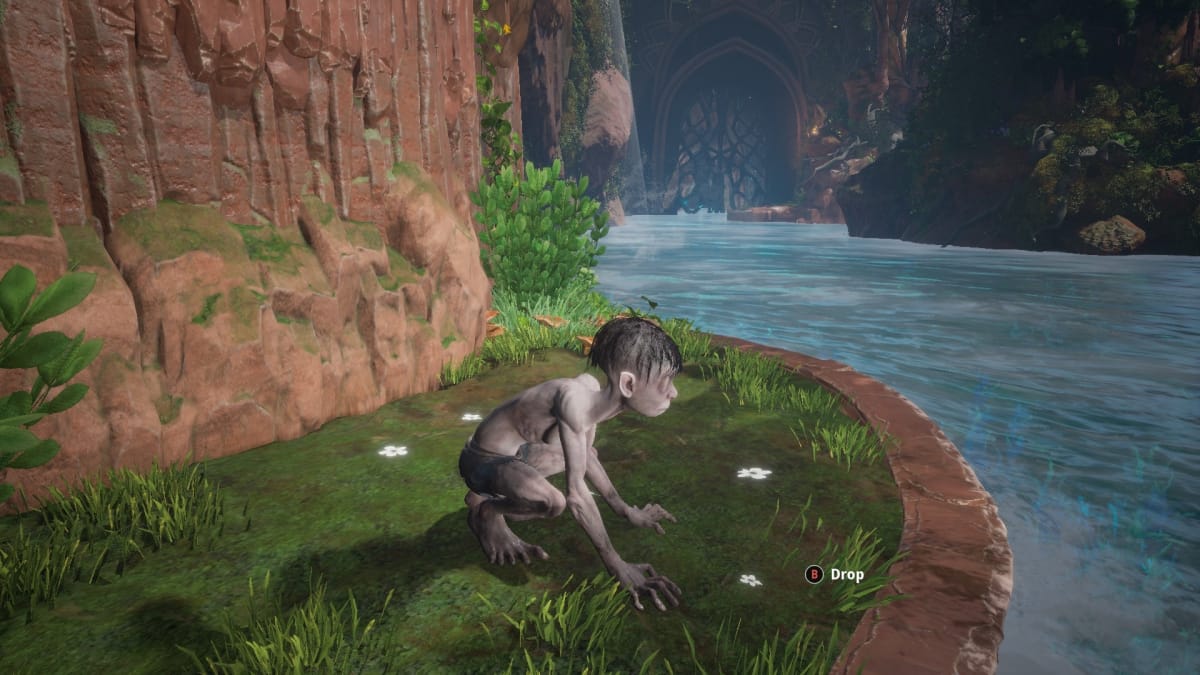 Gollum screenshot showing gollum crouched on a little grassy ledge over swift-flowing water. 
