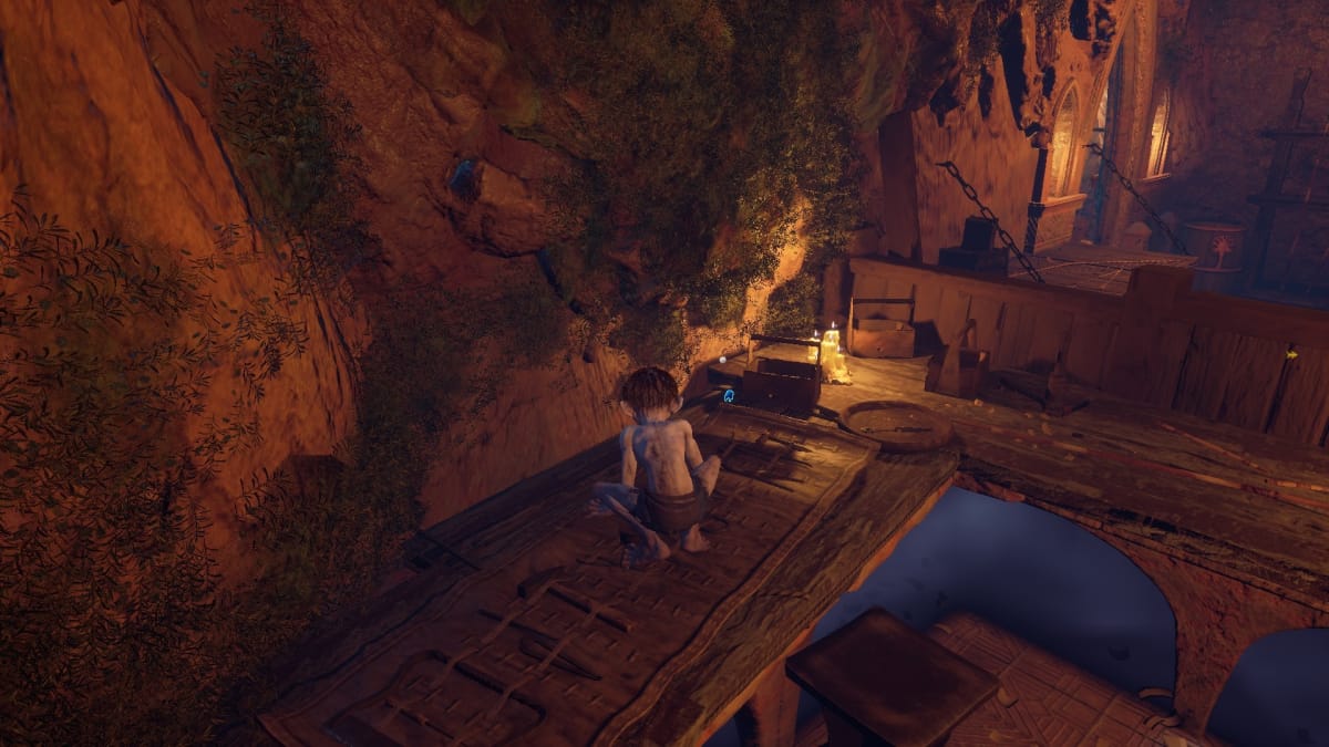 Gollum screenshot showing gollum crouching on a table with a blue-glowing bear-figurine nearby. 