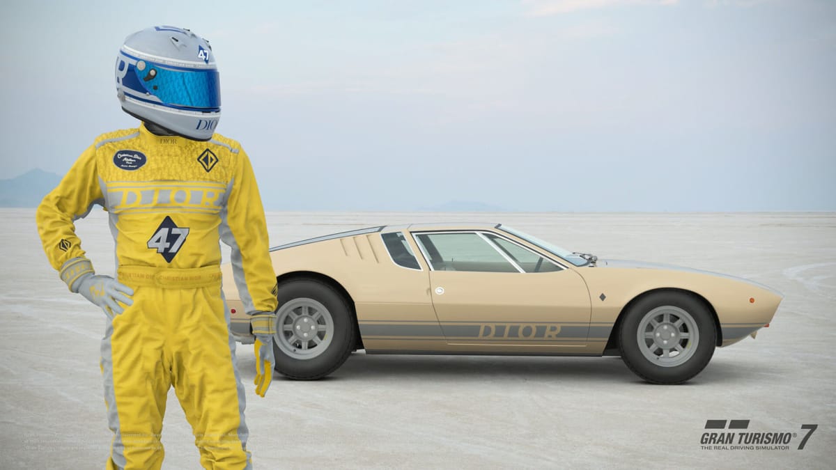 A driver wearing Dior livery standing next to the Italian De Tomaso Mangusta car, which has been redecorated with a Dior aesthetic in the new Gran Turismo 7 update