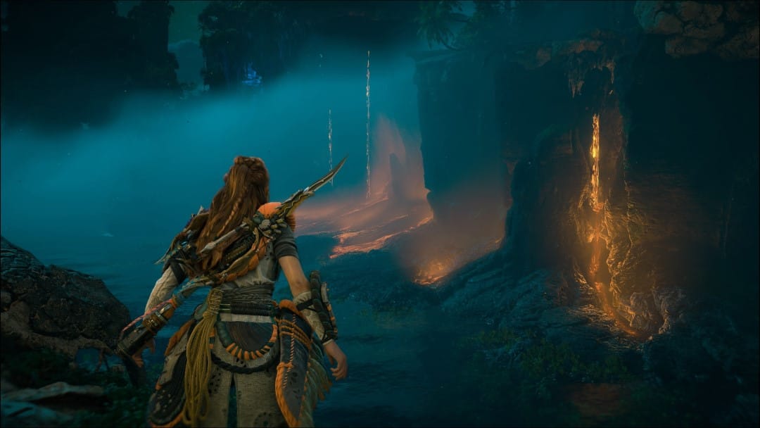 Aloy staring at a series of cliffs with lava running down them from Horizon Forbidden West: Burning Shores