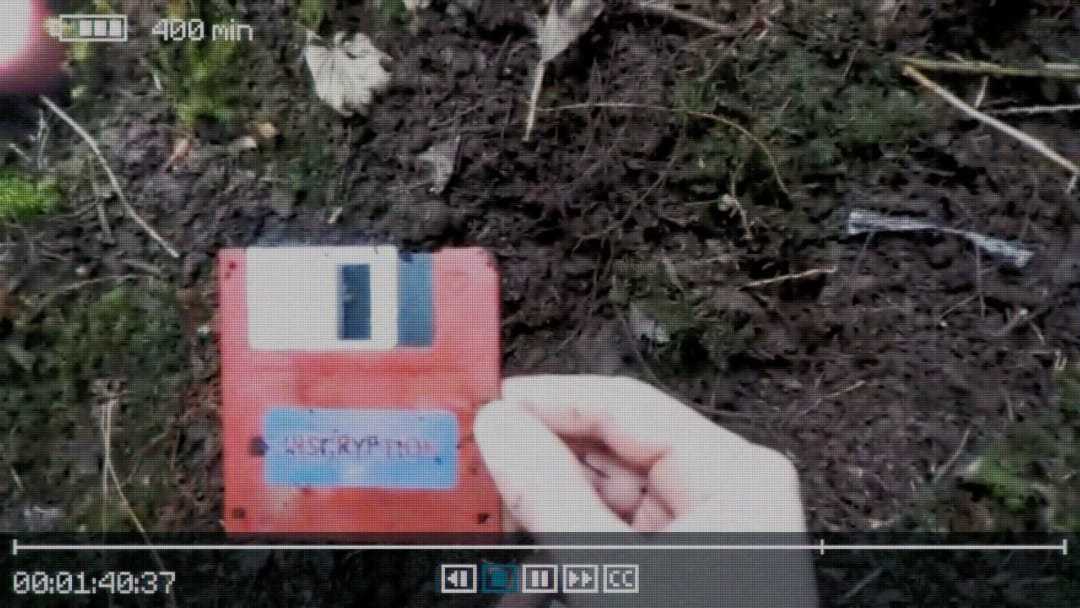 Live-action footage of someone pulling a floppy disk from the ground
