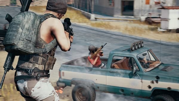 PUBG Screenshot of characters shooting at a moving truck within a dessert looking biome 