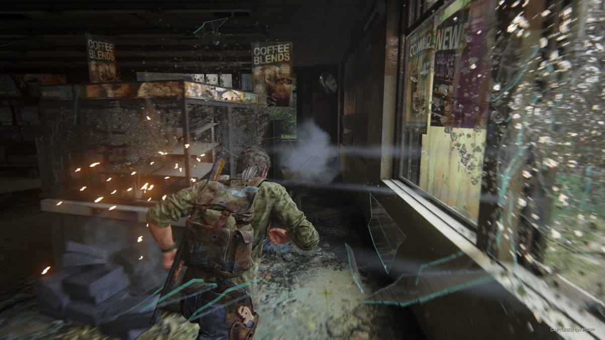 Joel sprinting through a disused building as glass shatters in The Last of Us Part I on Steam