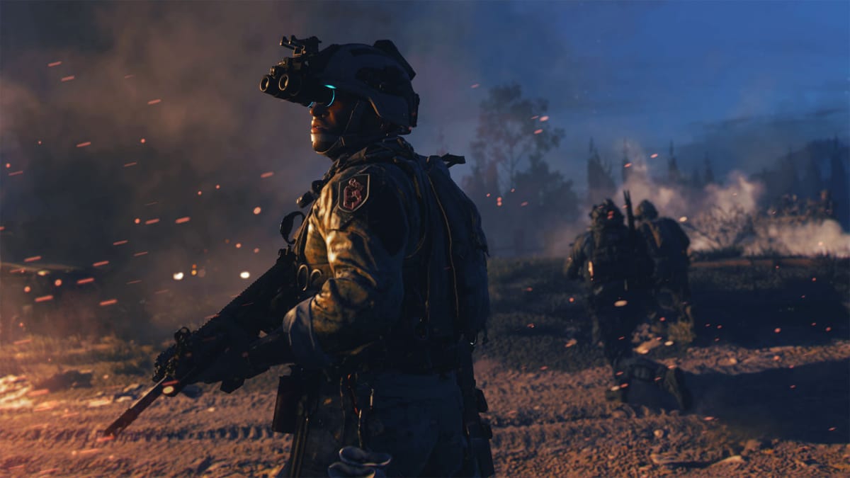 An in-engine screenshot of Call of Duty: Modern Warfare II (2022), showcasing a soldier looking towards an off-screen fire during a dark night.