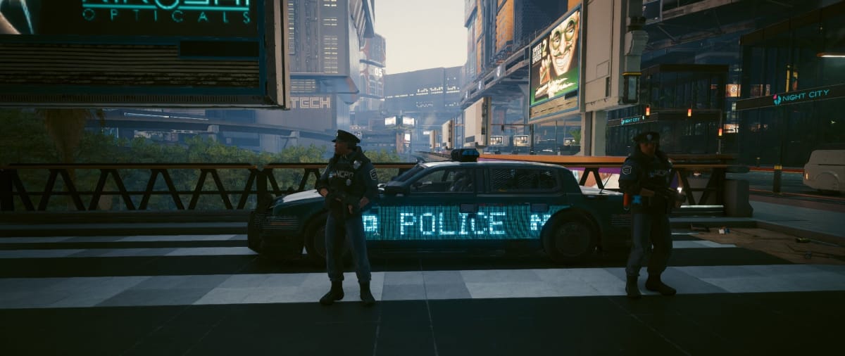 Two cops standing in front of a cop car in Night City in Cyberpunk 2077