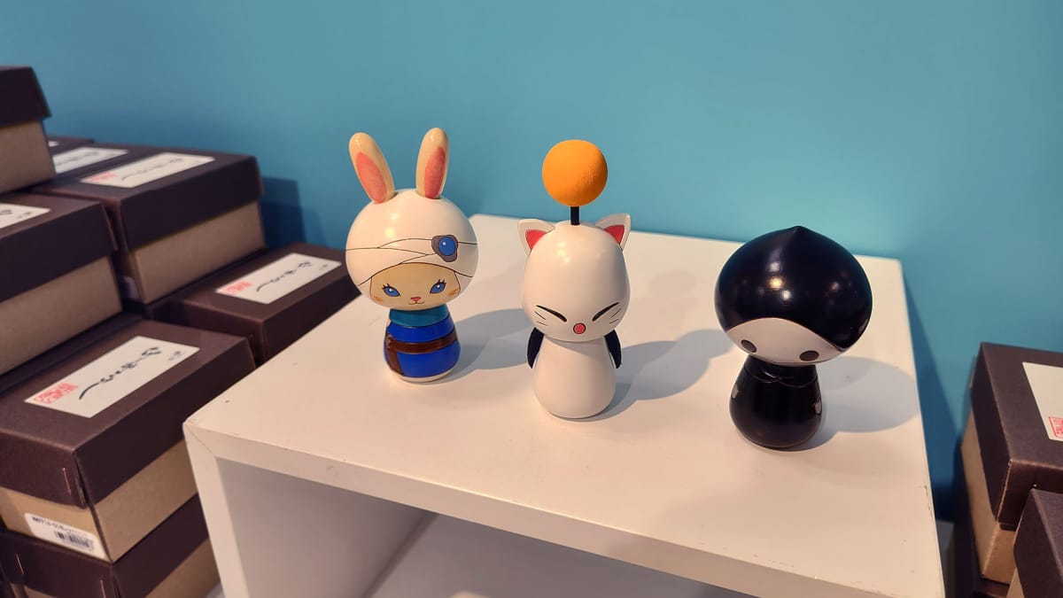 Minion Kokeshi sit on a display table at the A Decade's End Final Fantasy XIV event