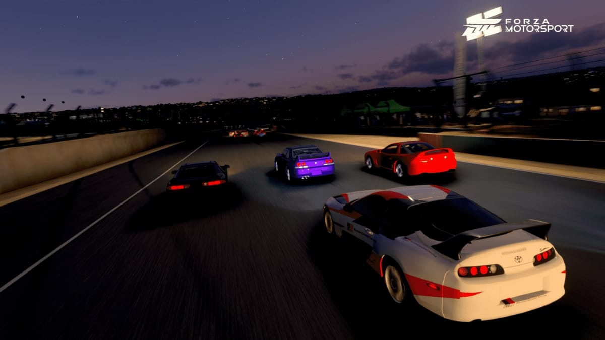 An in-game screenshot of Forza Motorsport, showcasing three cars driving alongside each other at night, with a white Toyota Supra driving behind the three in front. 