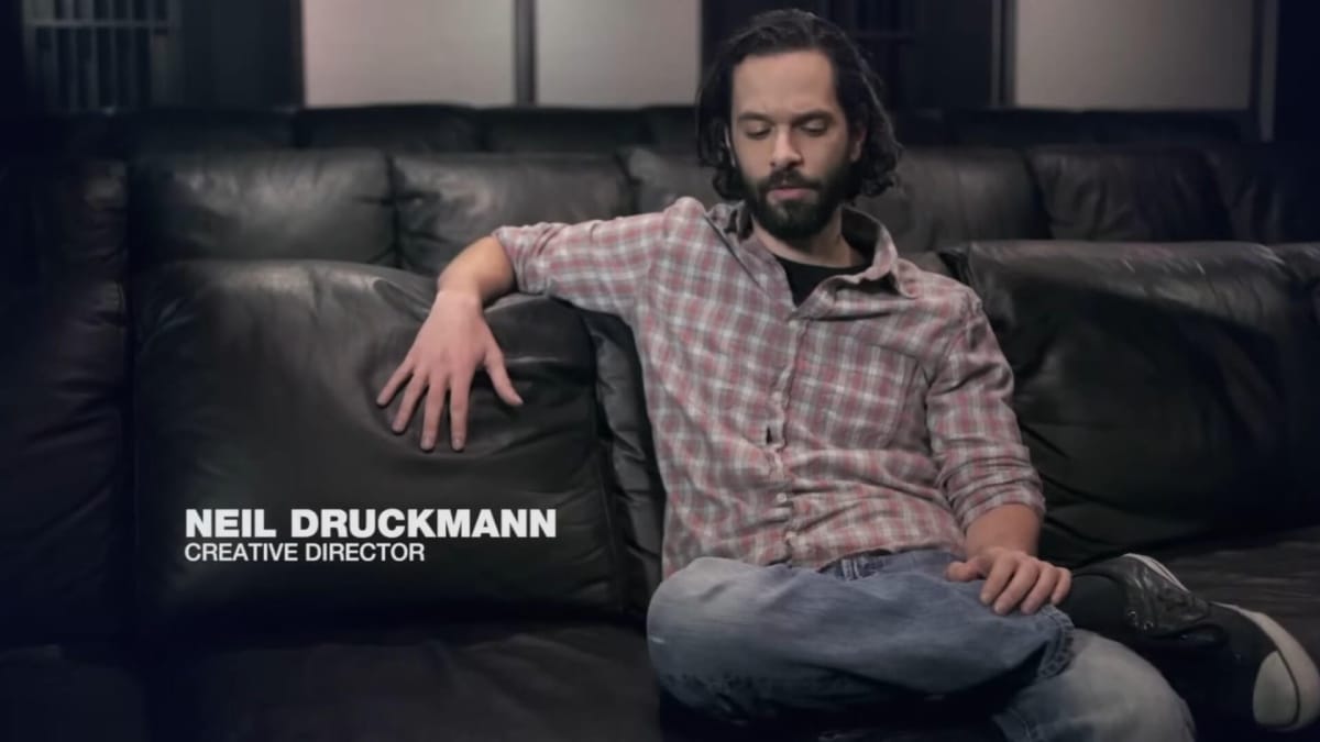 Neil Druckmann sitting on a sofa and talking as part of the Grounded: The Making of The Last of Us documentary
