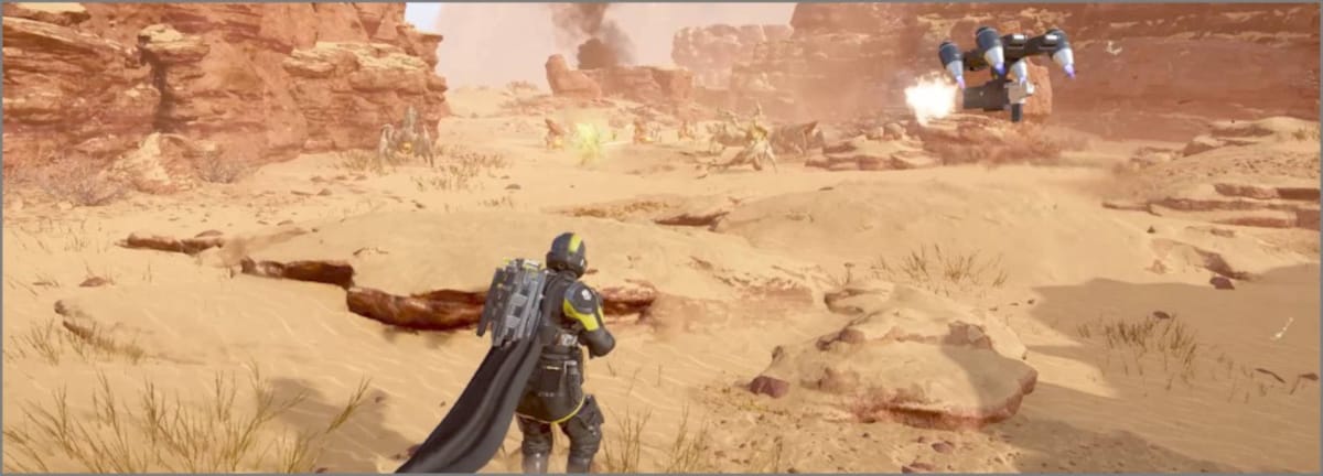 A flying Guard Dog drone shooting its assault rifle at approaching Terminid bugs on a desert planet in Helldivers 2