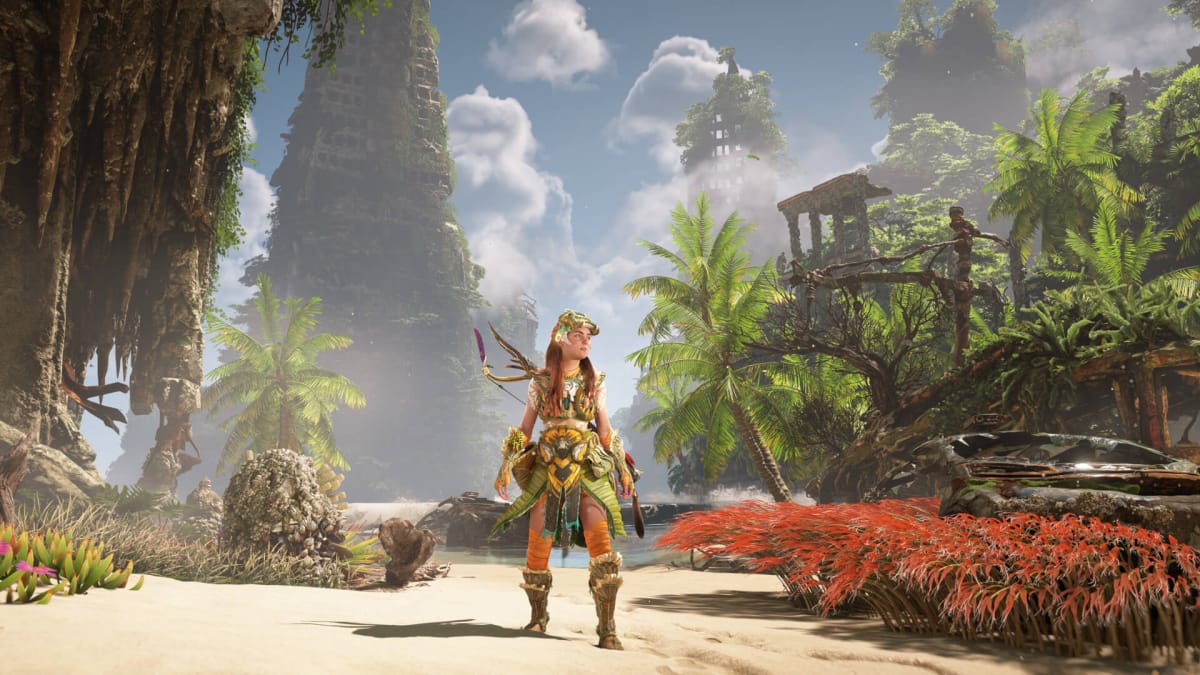 Aloy standing alone on a beach flanked by foliage in Horizon Forbidden West Complete Edition on PC