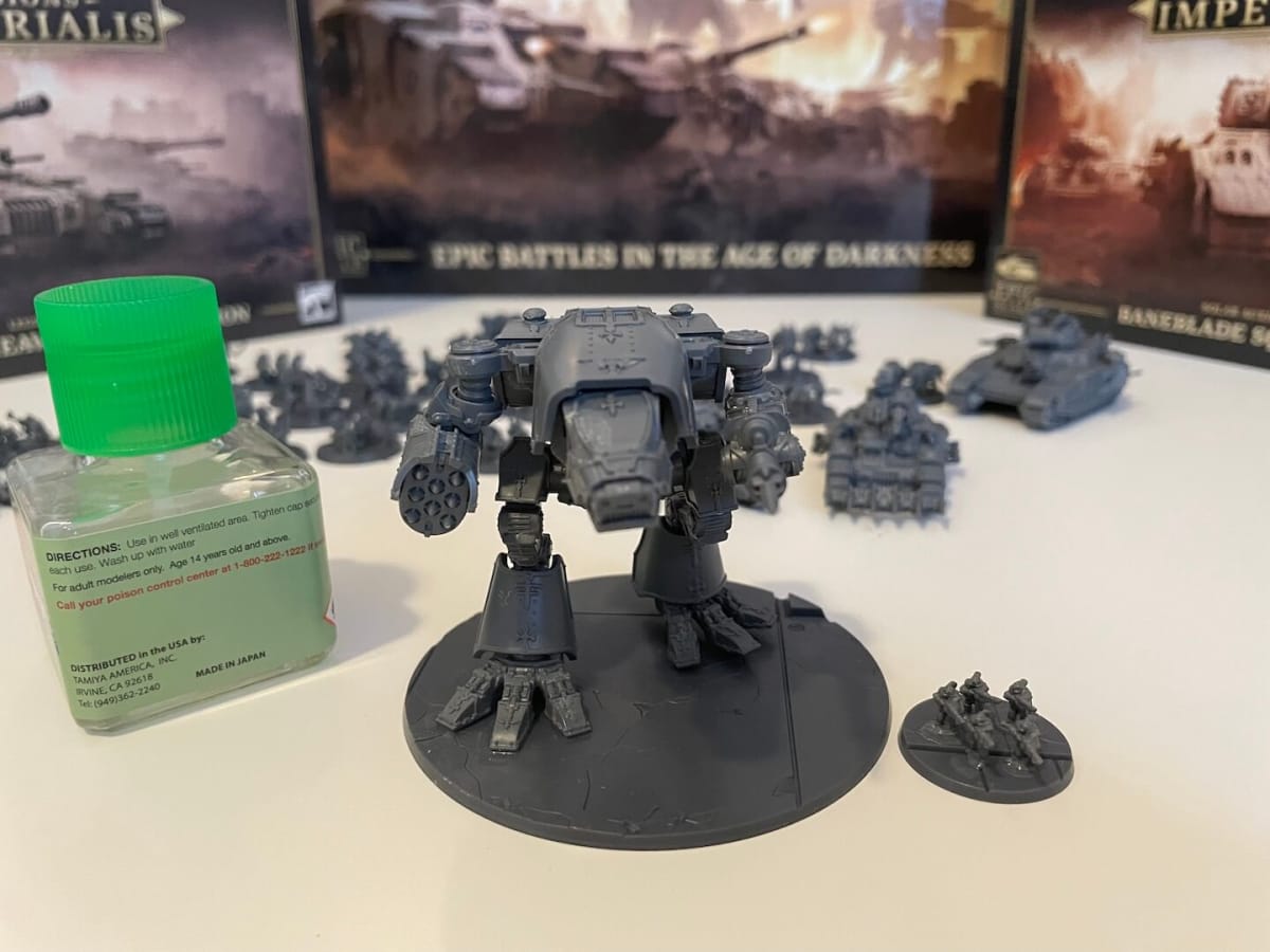 A Warhound Titan and a group of five Solar Auxilia infantry posed next to a glue bottle for scale reference.