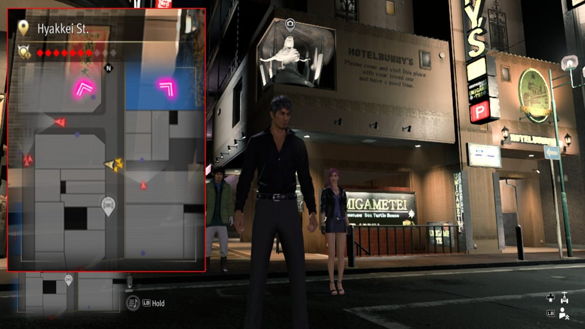 like a dragon infinite wealth screenshot showing a map reference and a glowing underlit statue suspended over the entrance to a hotel