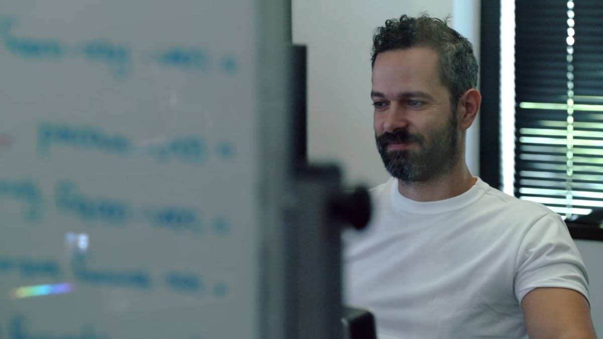 Neil Druckmann Smiles while looking at a whiteboard.