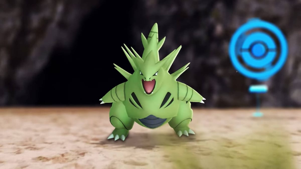 A Tyranitar roaring at the camera with a PokeStop in the background in Pokemon Go