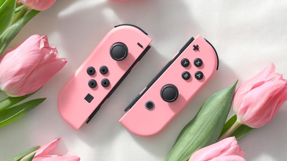 The pastel pink Joy-Cons next to some roses in the Princess Peach: Showtime! Joy-Con tie-in