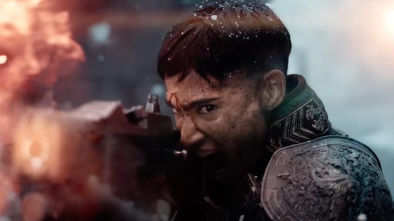 A screenshot from the Netflix movie Rebel Moon, showing a close up of a soldier firing a laser rifle