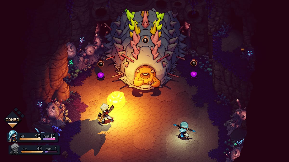 Two of the main characters battling a giant worm boss in a cave in Sea of Stars