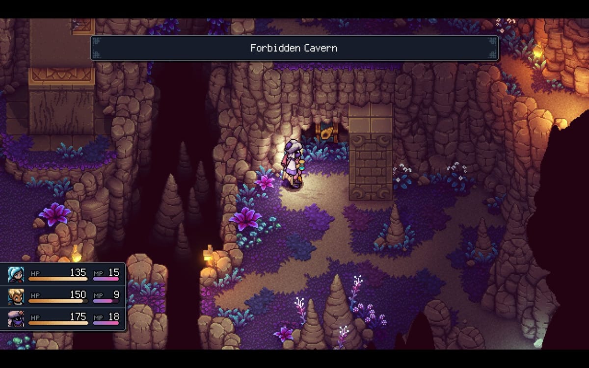 Standing next to a chest inside a small cavern.