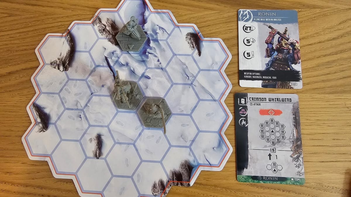 Several miniatures set up to show an example of how the hexes work on attack cards.