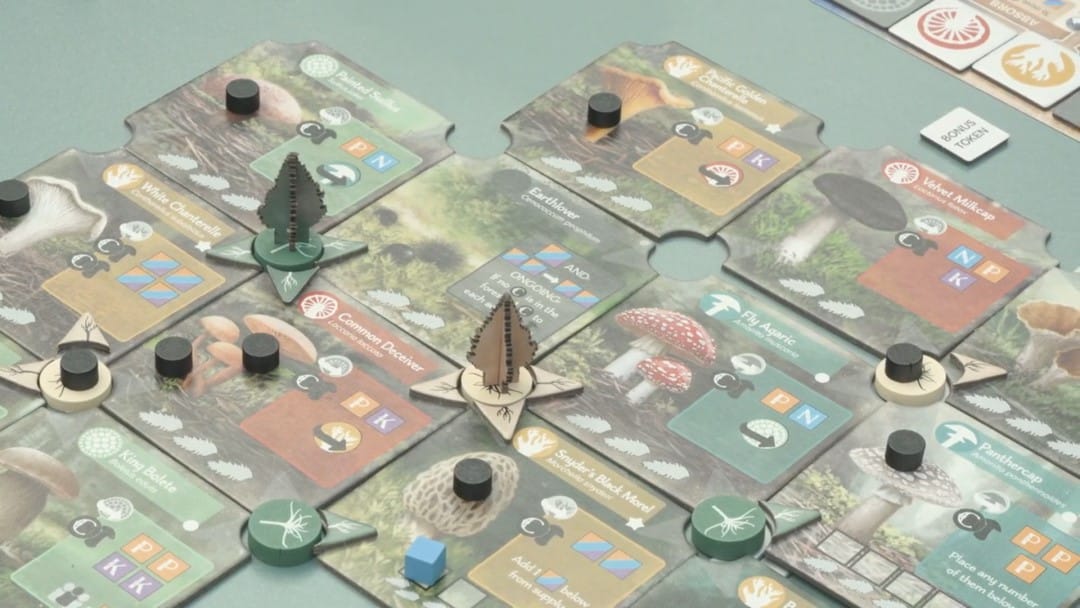 A screenshot of the Undergrove board game being played, showing off tiles and tree standees