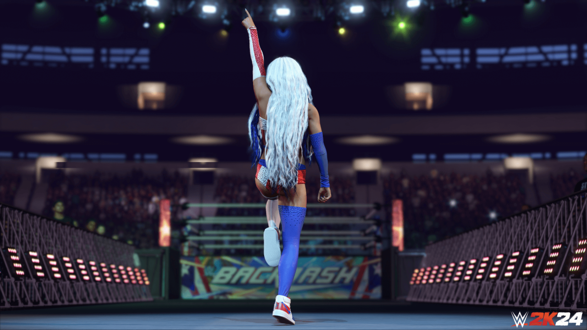 An in-engine screenshot of WWE 2k24, showcasing the wrestler Zelina Vega walking towards the wrestling ring.