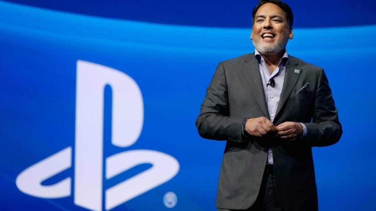 Shawn Layden in front of the PlayStation logo