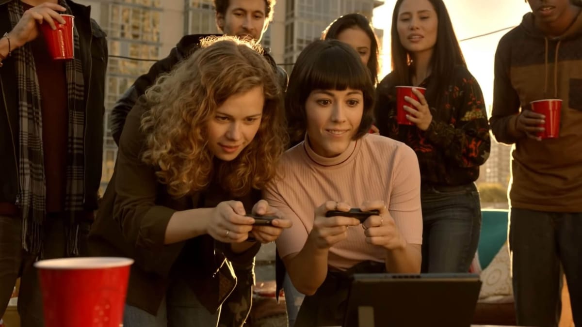 Gamers gathered around a Nintendo Switch on a rooftop